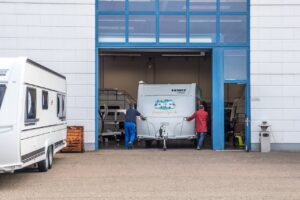 Wohnwagen wird in die Werkstatt geschoben.