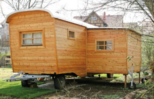 Ein Basic Tiny House aus Holz mit einem Erker