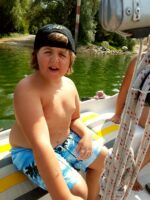 Junge mit Behinderung auf einem Segelboot