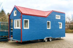 Blaues Tiny House aus Holz mit rotem Dach