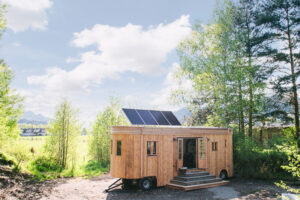 Ein Tiny House mit Solar auf dem Dach im Gruenen