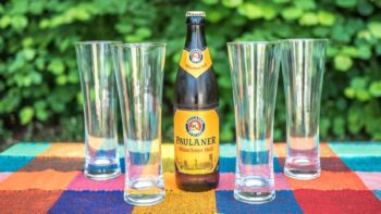 Bierglaeser und eine Flasche Bier auf einem Campingtisch