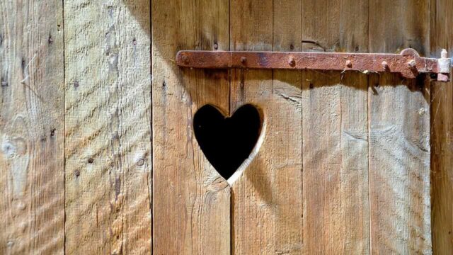 Ein Klohaeuschen aus Holz mit Herz in der Mitte