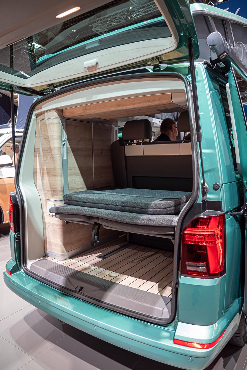 VW California 6.1 – Strand-Hopping mit Stil (inkl. Video-Roomtour) 30 Blick von hinten auf die geöffnete Heckklappe eines VW California 6.1 Coast auf dem Messestand des Caravan Salon 2019 in Düsseldorf