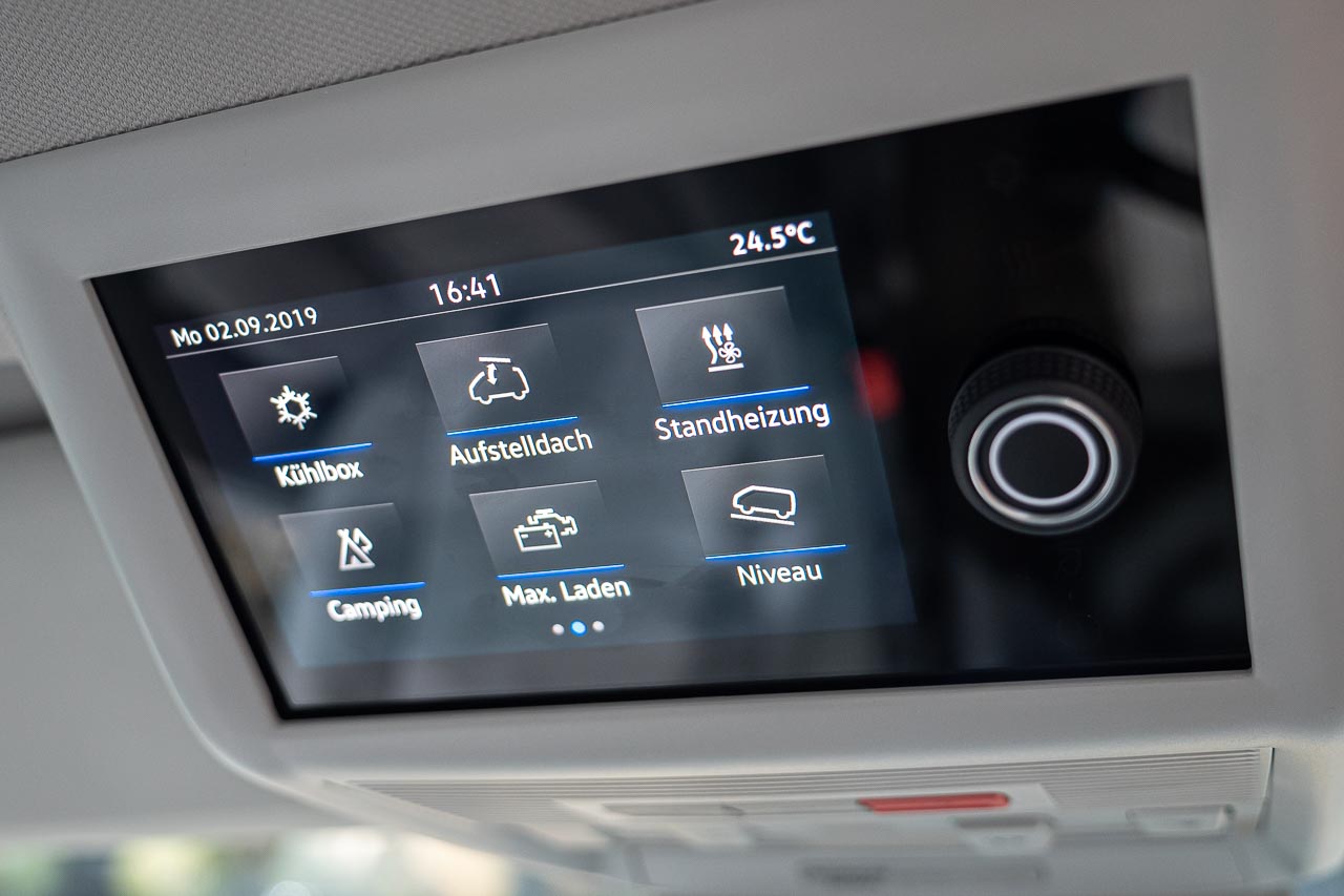 VW California 6.1 – Strand-Hopping mit Stil (inkl. Video-Roomtour) 28 Blick auf das Display mit Camping-Fahrzeugdaten im vorderen Himmel eines VW California 6.1 auf dem Messestand des Caravan Salon 2019 in Düsseldorf