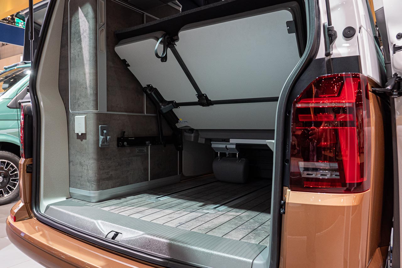 VW California 6.1 – Strand-Hopping mit Stil (inkl. Video-Roomtour) 6 Blick von hinten auf die geöffnete Heckklappe eines VW California 6.1 Ocean auf dem Messestand des Caravan Salon 2019 in Düsseldorf