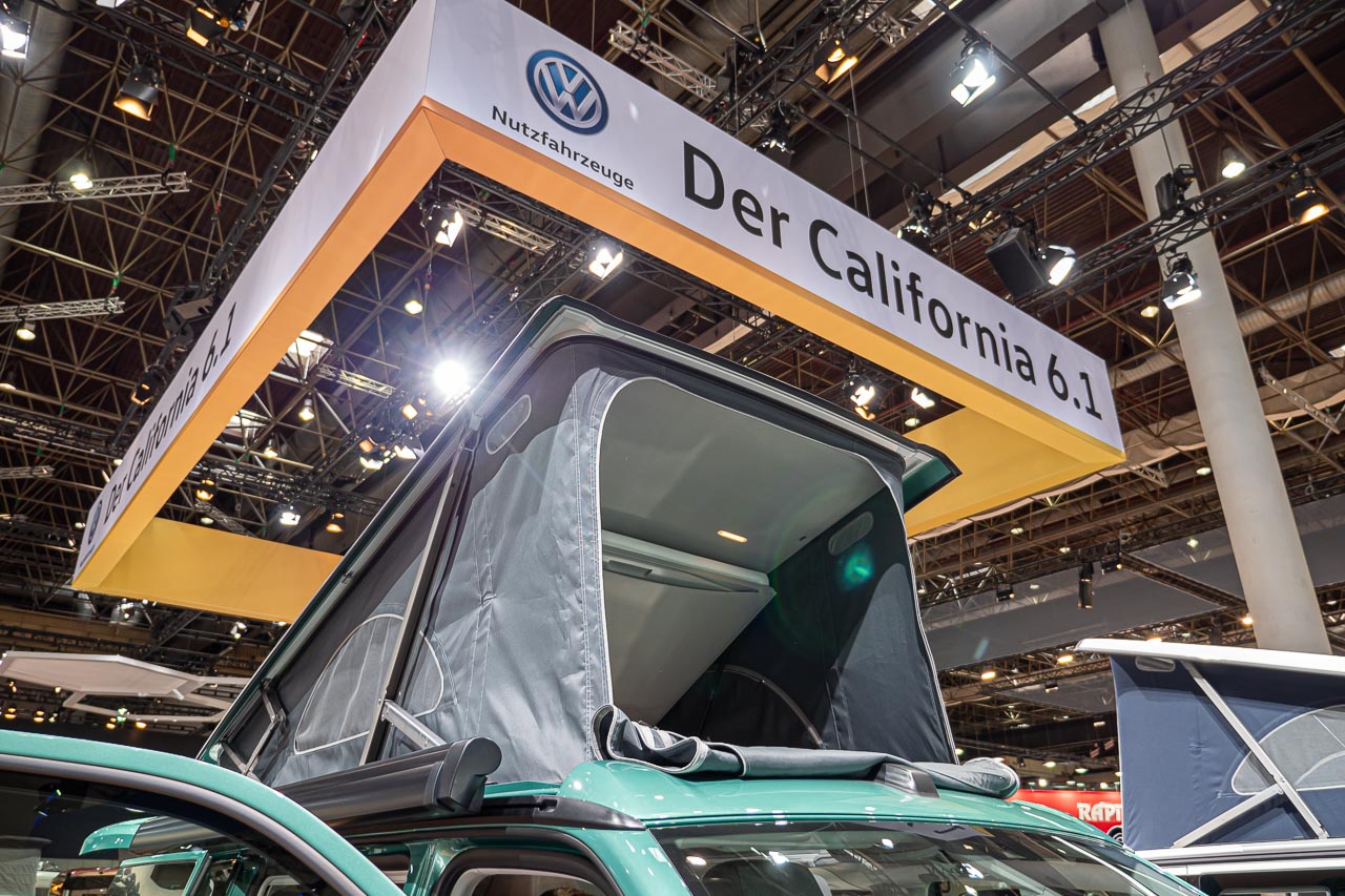 VW California 6.1 – Strand-Hopping mit Stil (inkl. Video-Roomtour) 1 Blick auf das geöffnete Hochdach eines VW California 6.1 Coast auf dem Messestand des Caravan Salon 2019 in Düsseldorf