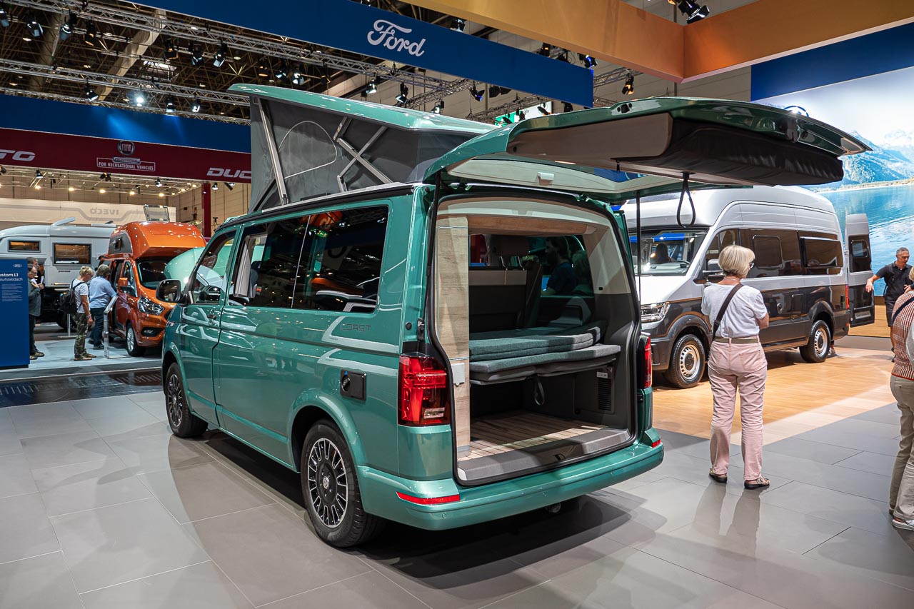 VW California 6.1 – Strand-Hopping mit Stil (inkl. Video-Roomtour) 4 Blick von hinten auf einen VW California 6.1 Coast mit offener Heckklappe und aufgestelltem Hochdach auf dem Messestand des Caravan Salon 2019 in Düsseldorf
