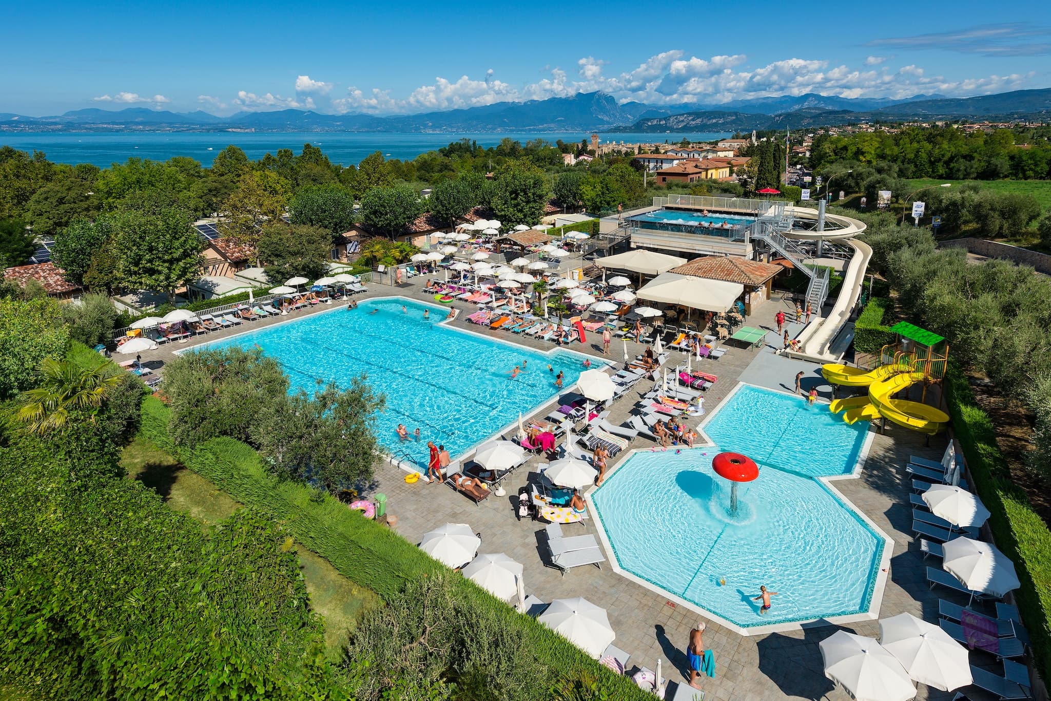 Camping am Gardasee mit Kind – Familienparadies in Italien 10 Camping Du Parc Campingplatz aus der Vogelperspektive mit Pool Wasserrutsche Liegestuehlen und Sonnenschirmen