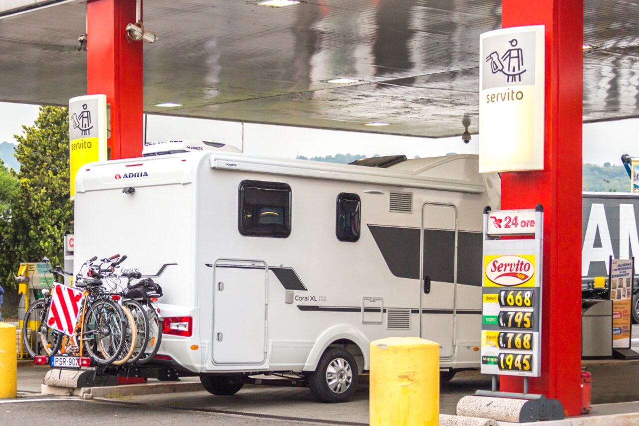 Ein Wohnmobil steht an einer Tanksäule an einer Tankstelle.