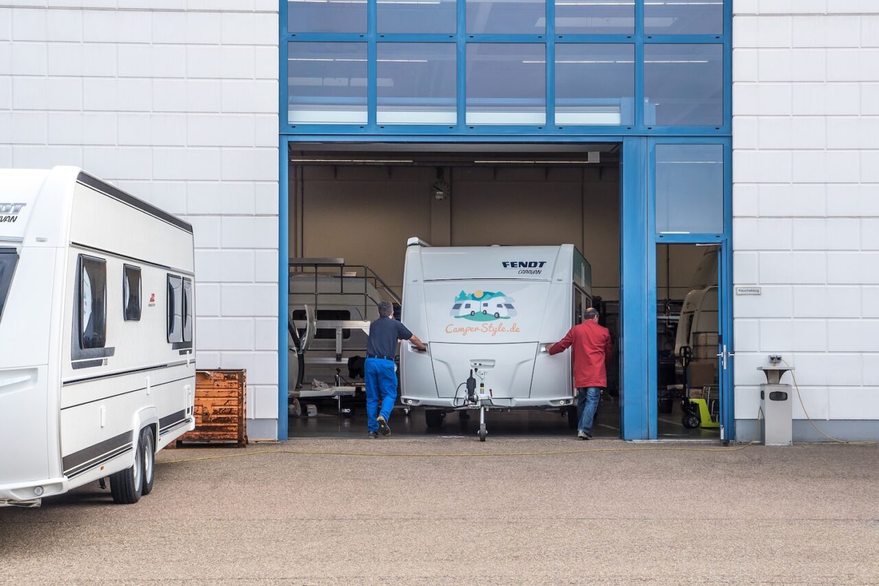 Wohnwagen wird zur Dichtigkeitsprüfung in die Werkstatt geschoben